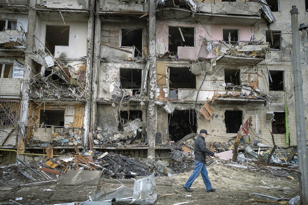 A man walks past a building damaged following a rocket attack in Kyiv on Feb. 25. (AP Photo/Emilio Morenatti, File)
