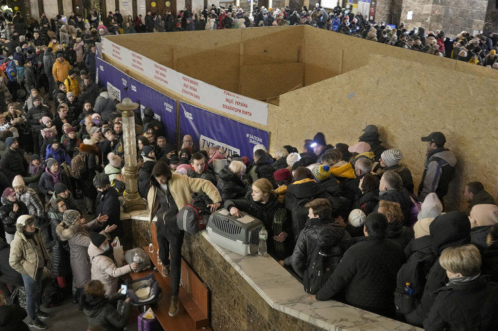 People struggle on stairways after a last minute change of the departure platform for a Lviv bound train in Kyiv, Ukraine, on Monday. Explosions and gunfire that have disrupted life since the invasion began last week appeared to subside around Kyiv overnight, as Ukrainian and Russian delegations met Monday on Ukraine’s border with Belarus. (AP Photo/Vadim Ghirda)
