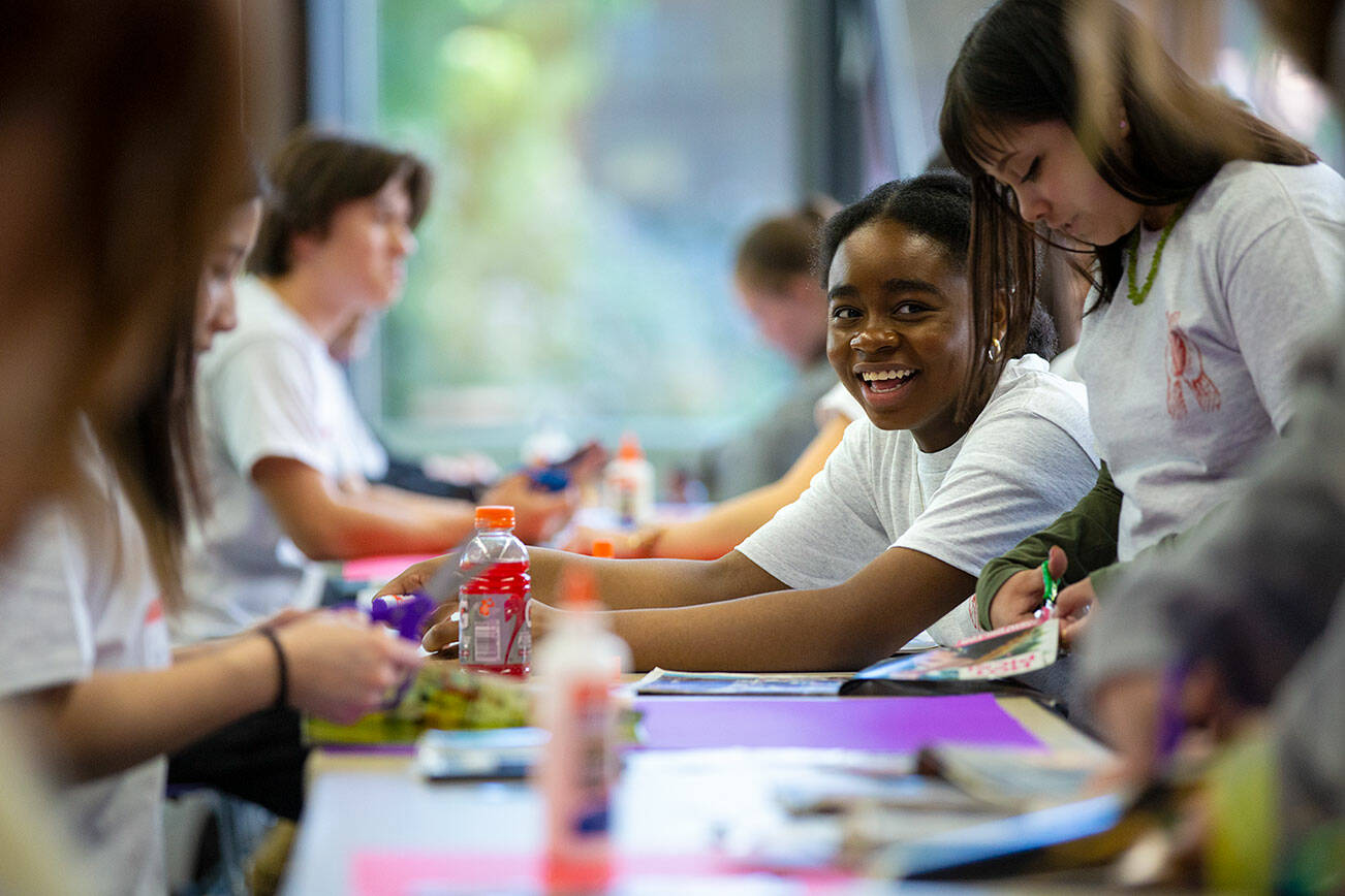 Glenda Wabaluku, 17, works together with a group of peers to piece together a creative action plan for their communities during Leadership Launch’s "Emotion Commotion" event on Saturday, May 21, 2022, at Everett Community College in Everett, Washington. (Ryan Berry / The Herald)