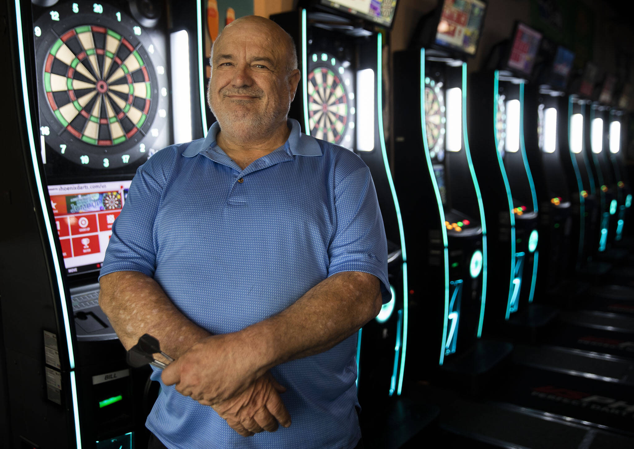 Flint Ferguson, Bernadette “Bernie” Johnson’s partner, stands next to the dart boards inside the Clubhouse Bar and Grill in Everett where Bernie would play darts regularly. (Olivia Vanni / The Herald)