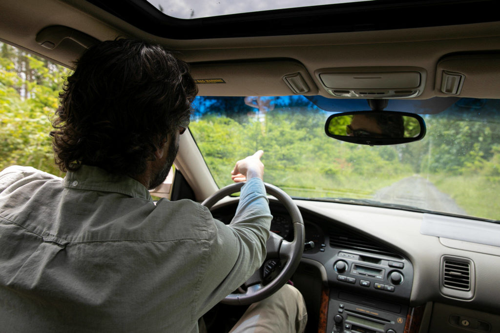 Ryan Elting, conservation director at the Whidbey Camano Land Trust, drives through a forested section of the Keystone Preserve on June 10 near Coupeville. The wooded areas of the preserve will feature trails for people to walk on. (Ryan Berry / The Herald)
