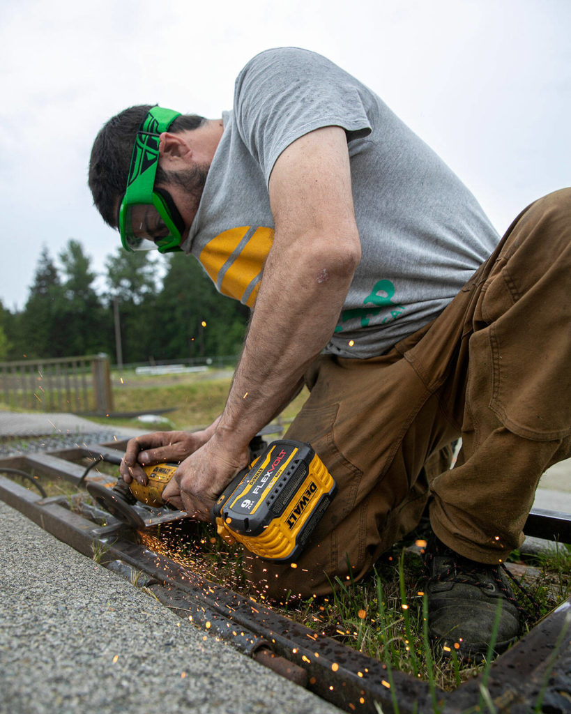 Maiki Gonzalez works on welding improvements to the starting gate at the beginning of the course Wednesday at the Bigfoot BMX track near Everett. (Ryan Berry / The Herald)
