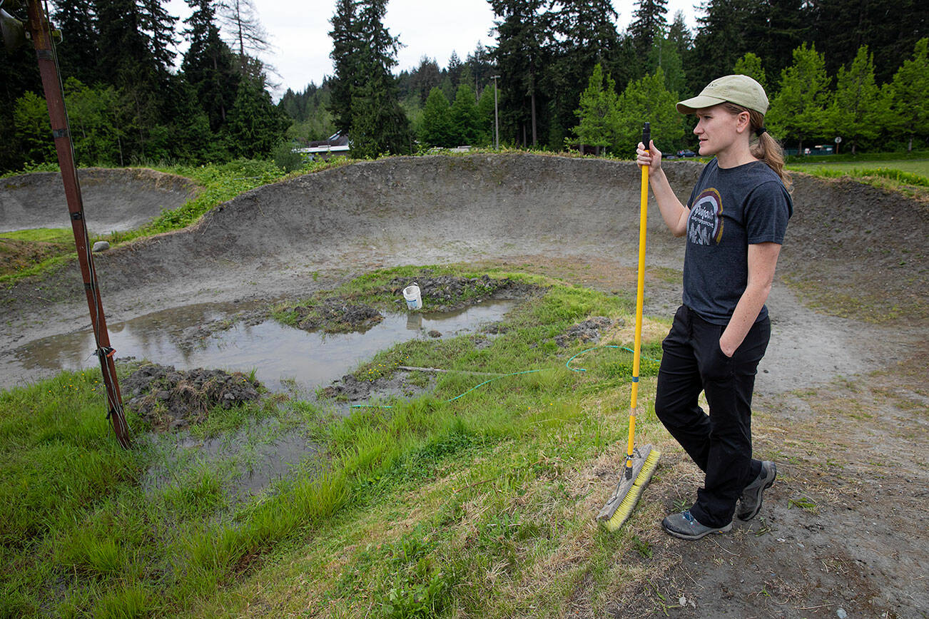 Bigfoot BMX treasurer Jamie Holland looks over a portion of the track that is flooded after a wet spring on Wednesday, June 1, 2022, at the Bigfoot BMX track in Everett, Washington. Members of the group are uncertain when they’ll be able to open up the track to events due to poor drainage. (Ryan Berry / The Herald)