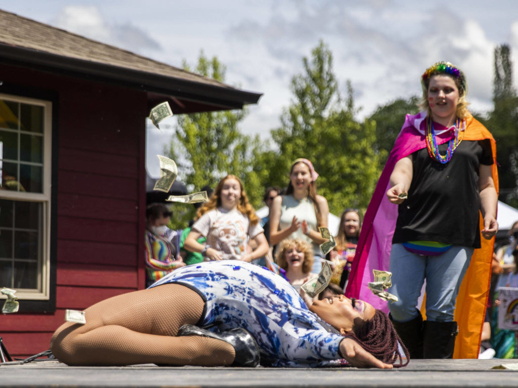 Devlin Lynn Phoenixx throws cash in the air while performing at Arlington’s first-ever Pride celebration Saturday at Legion Memorial Park. (Olivia Vanni / The Herald)
