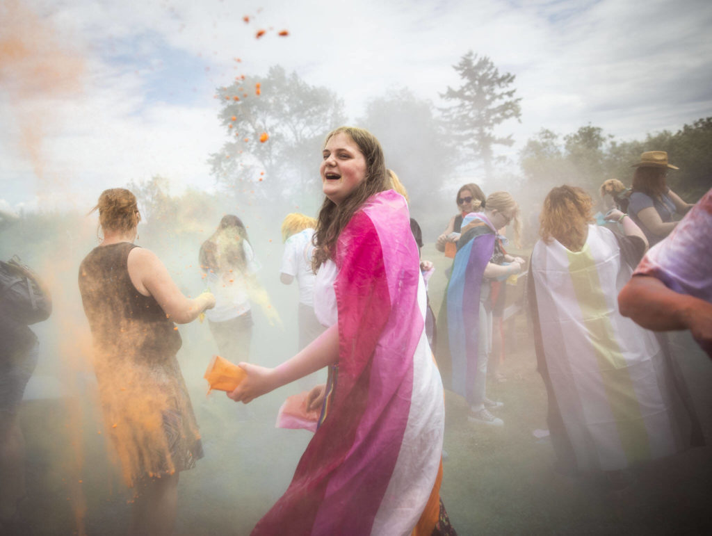 Mia Roue, 14, participates in a color throw at Stanwood and Camano’s first-ever Pride celebration Saturday at Freedom Park. (Olivia Vanni / The Herald)
