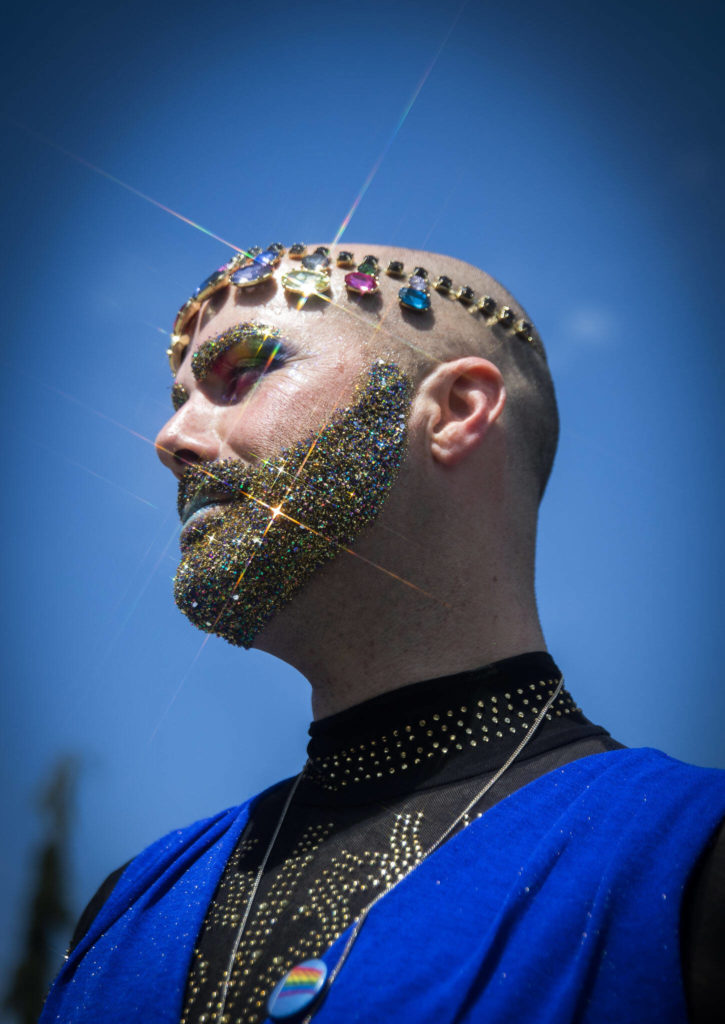 Gina Touche’s glitter beard and jewels shine in the sunlight at Arlington’s first-ever Pride celebration Saturday at Legion Memorial Park. (Olivia Vanni / The Herald)
