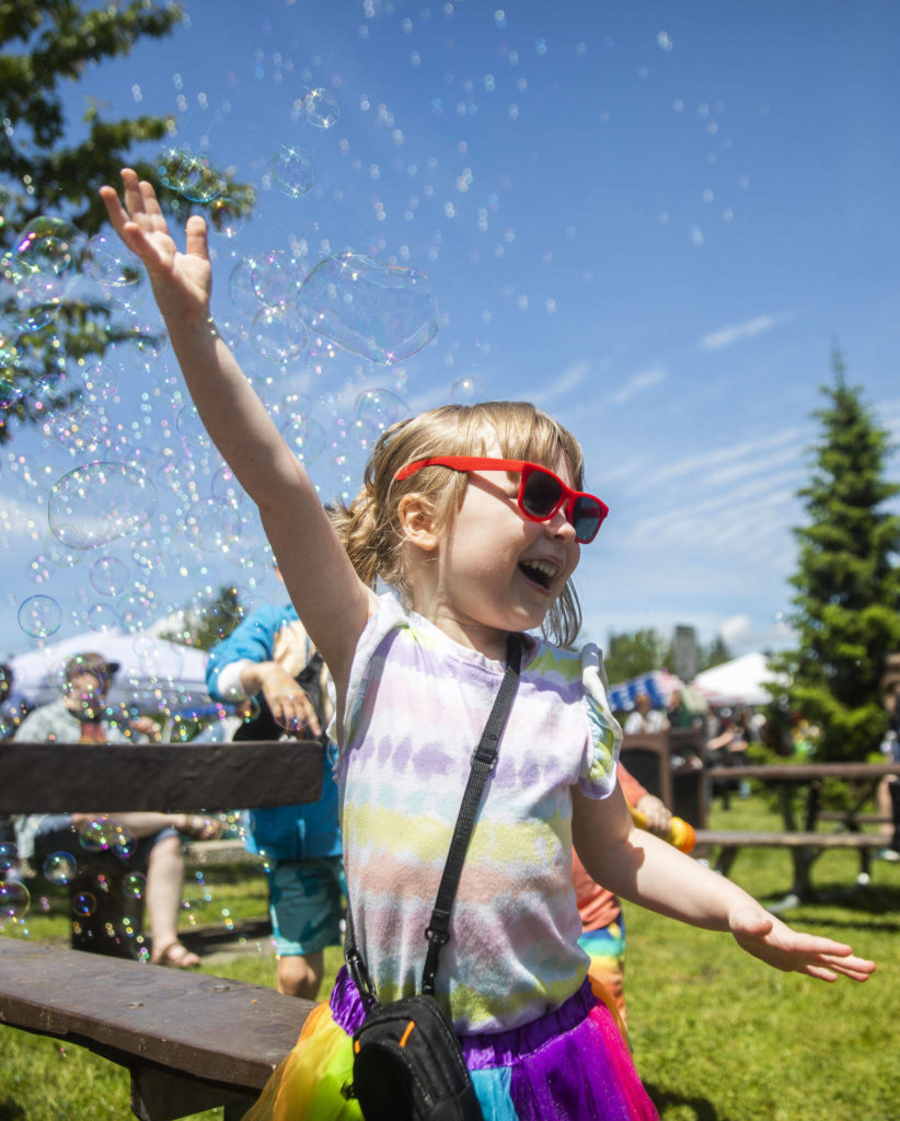 Kaydence Miller, 4, laughs while playing in bubbles at Arlington’s first-ever Pride celebration Saturday at Legion Memorial Park. (Olivia Vanni / The Herald)
