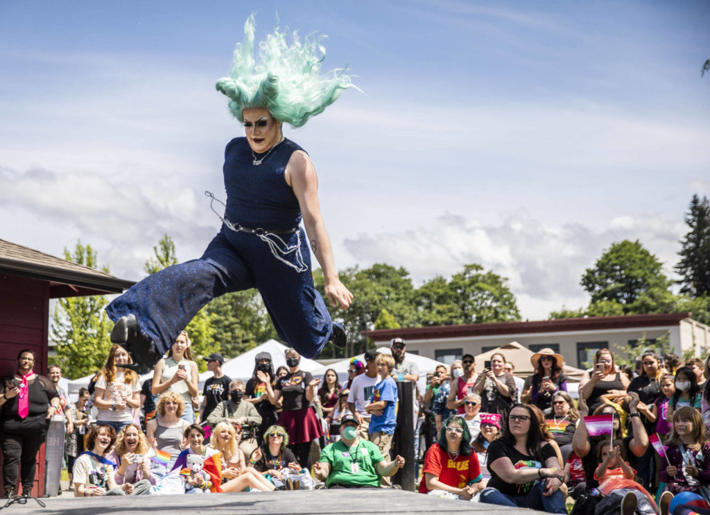 Tia Rikki leaps in the air during a drag performance at Arlington’s first-ever Pride celebration Saturday at Legion Memorial Park. (Olivia Vanni / The Herald)
