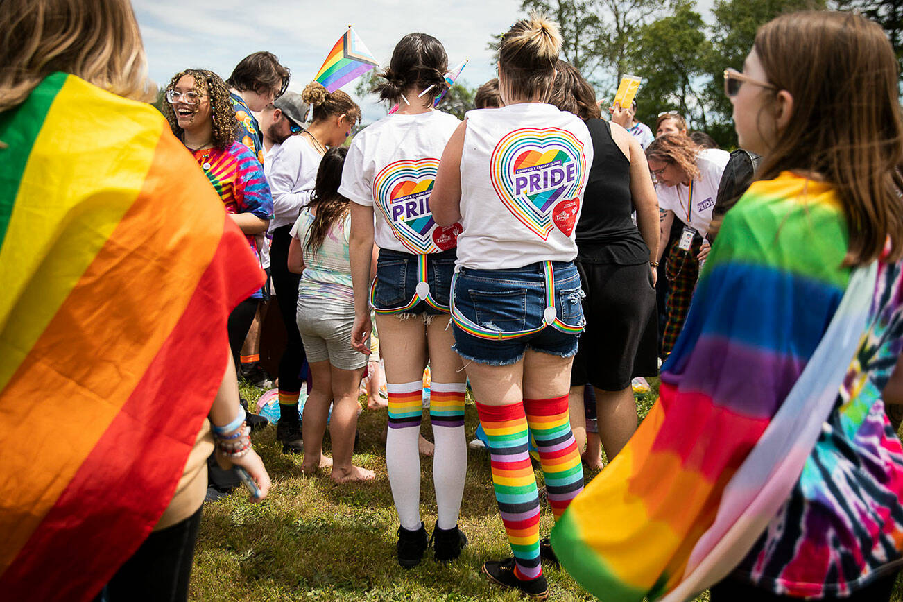 People gather for a color throw at Stanwood and Camano’s first-ever Pride celebration on Saturday, June 4, 2022. (Olivia Vanni / The Herald)
