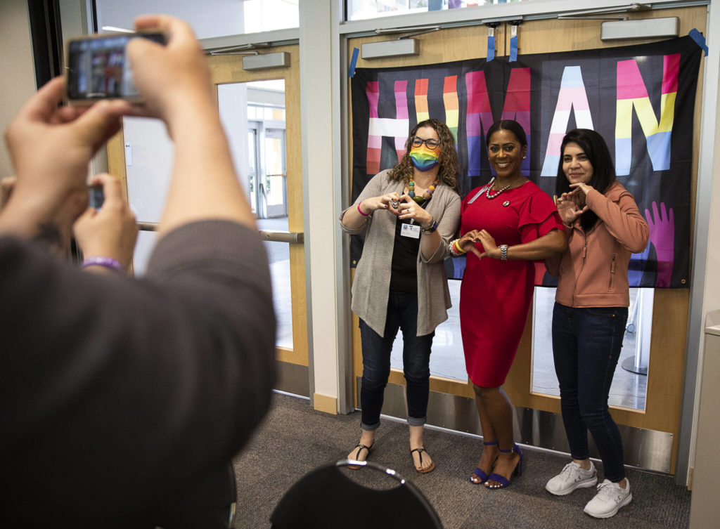 People pose with a pride flag during the Everett Public Schools Pride celebration Wednesday in Everett. (Olivia Vanni / The Herald)
