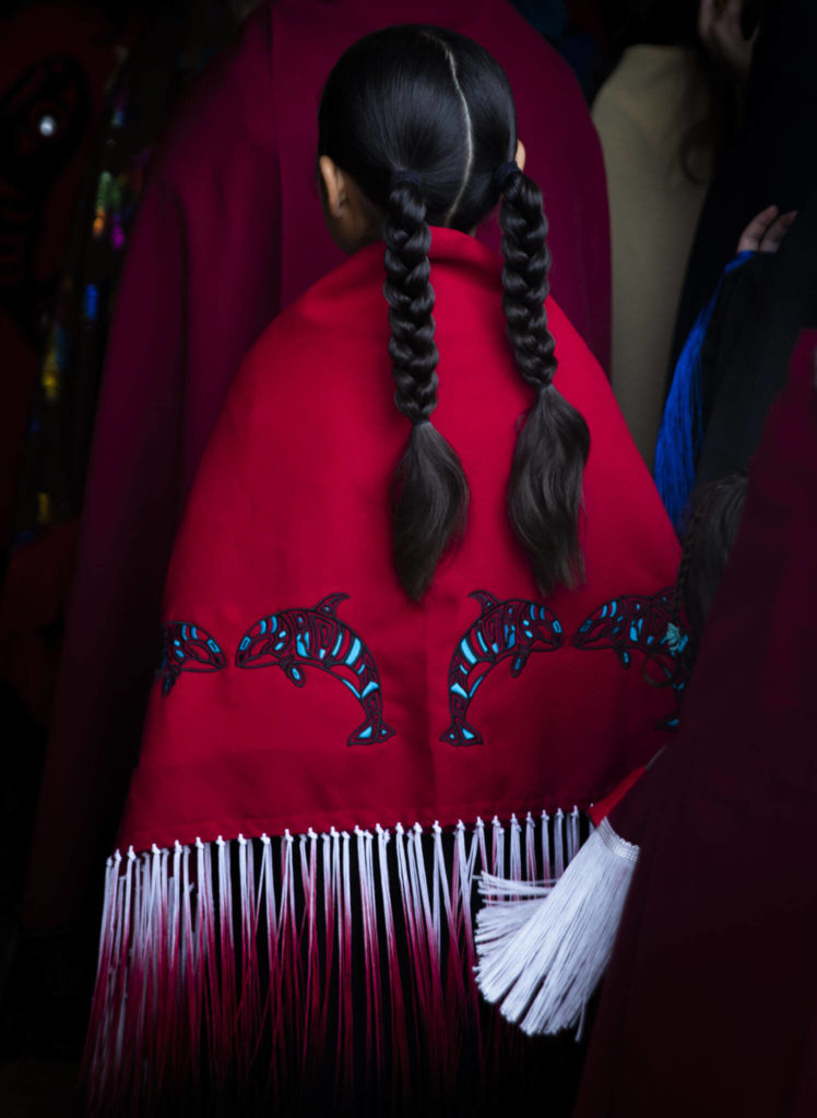 A young girl walks into the longhouse for the Salmon Ceremony on Saturday in Tulalip. (Olivia Vanni / The Herald) 

