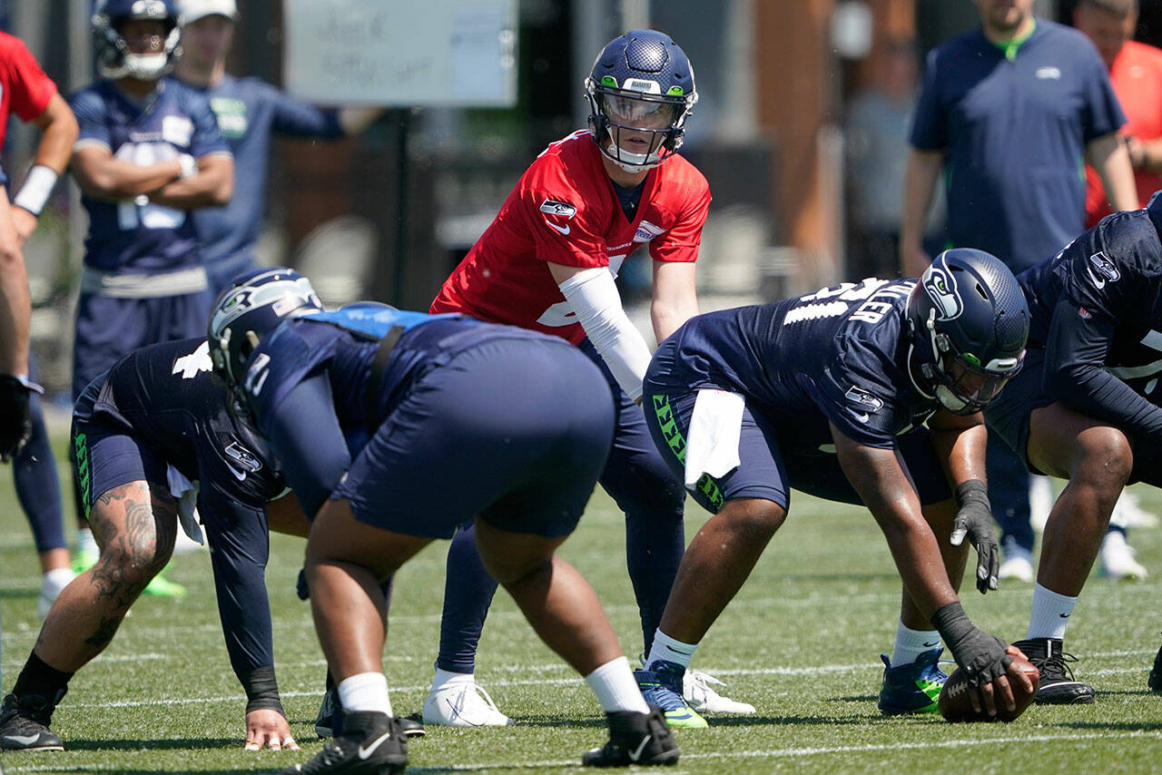 Seattle Seahawks quarterback Drew Lock (2) takes a snap from center Kyle Fuller during practice May 31 in Renton. (AP Photo/Ted S. Warren)