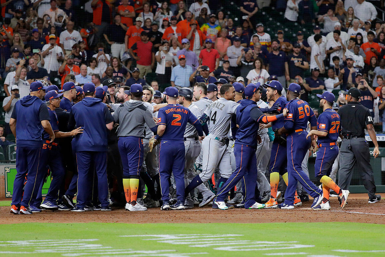 Both dugouts empty and umpires try to keep order after Seattle Mariners batter Ty France was hit by a pitch from Houston Astros relief pitcher Hector Neris during the ninth inning of a baseball game Monday, June 6, 2022, in Houston. (AP Photo/Michael Wyke)