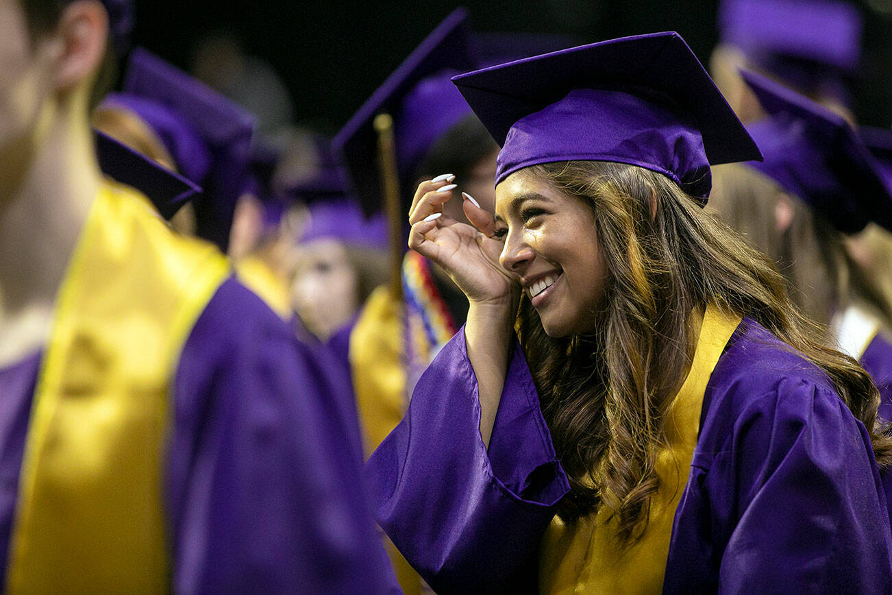 A student wipes away tears as the 592 graduates take their places during the processional at Lake Stevens High School’s 2022 commencement ceremony Tuesday, June 7, 2022, at Angel of the Winds Arena in Everett, Washington. (Ryan Berry / The Herald)