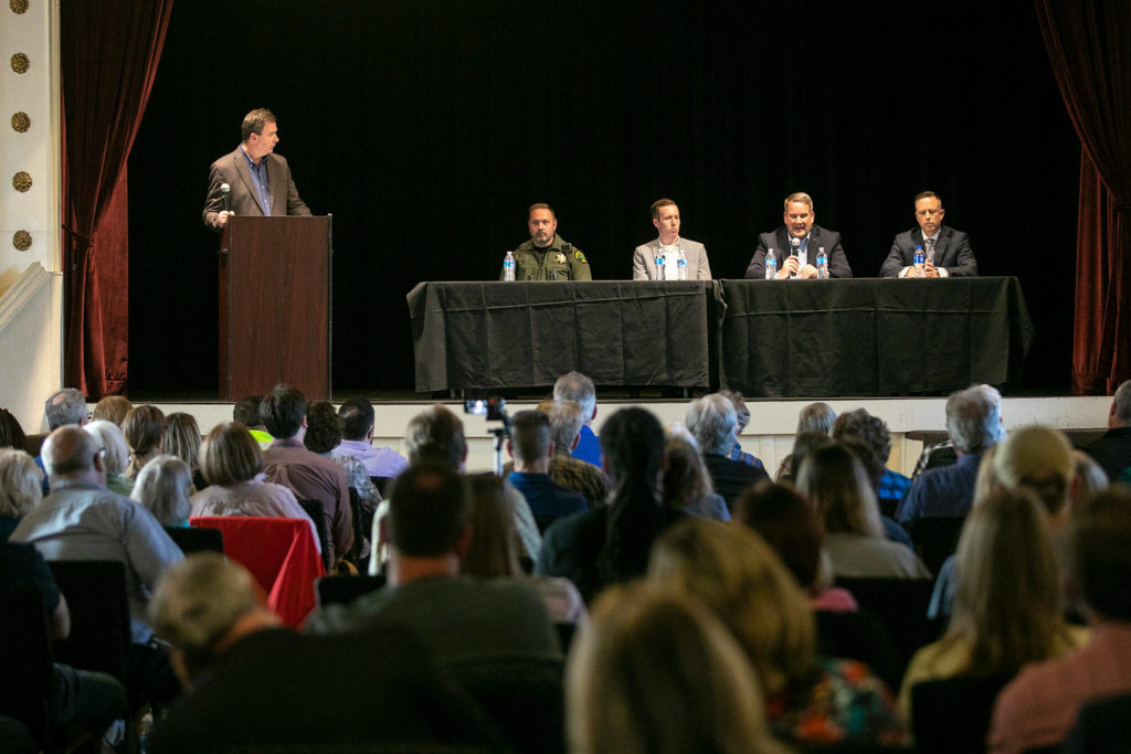 A packed house watches a panel consisting of (seated, from left) Sheriff Adam Fortney, County Council members Nate Nehring and Sam Low, and Matt Baldock, chief criminal deputy prosecutor, during a public safety town hall meeting Wednesday at the Marysville Opera House in Marysville. (Ryan Berry / The Herald)
