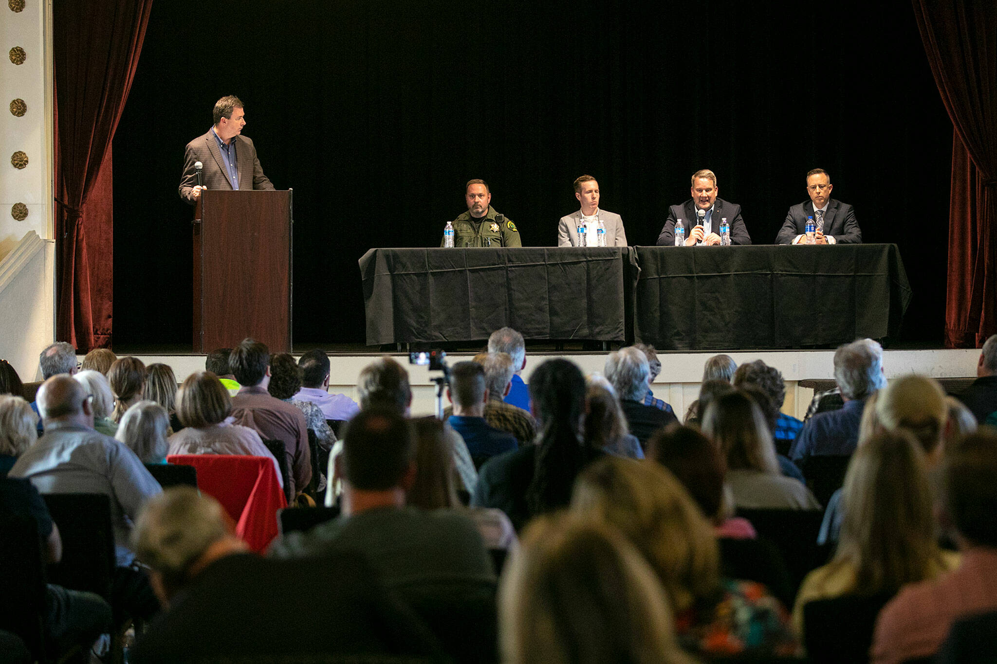 A packed house watches a panel consisting of (seated, from left) Sheriff Adam Fortney, County Council members Nate Nehring and Sam Low, and Matt Baldock, chief criminal deputy prosecutor, during a public safety town hall meeting Wednesday at the Marysville Opera House in Marysville. (Ryan Berry / The Herald)