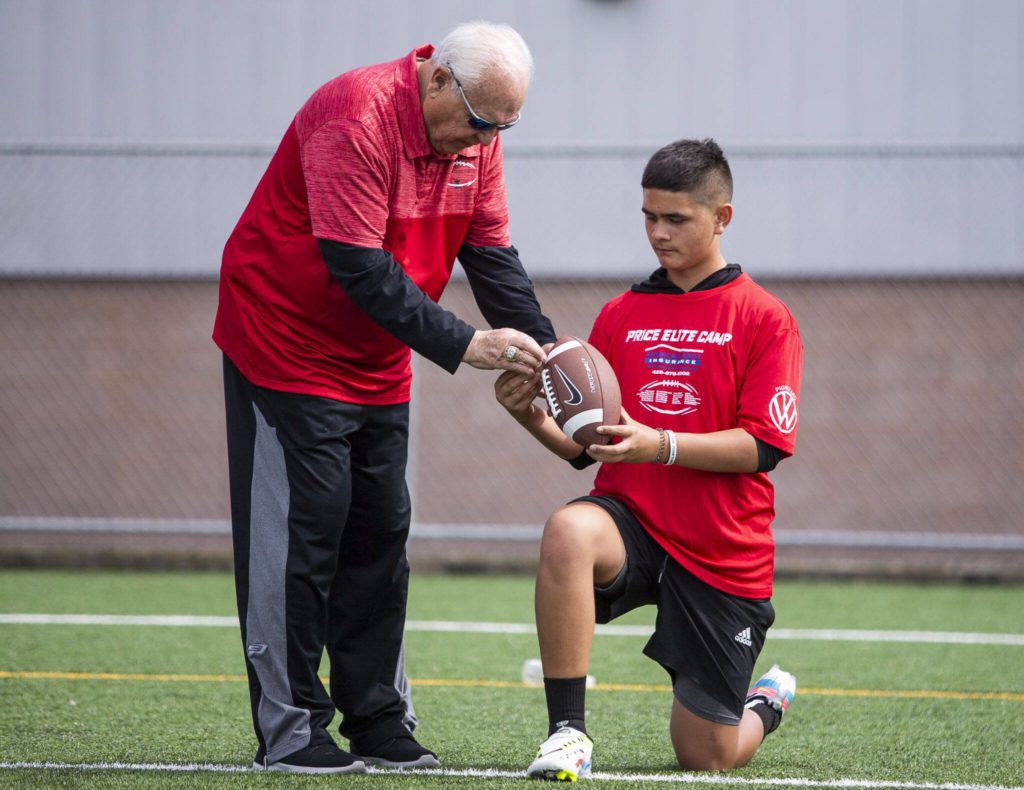 College football coaching legend Mike Price works with a player on his throwing technique during his Price Elite Passing Academy on Wednesday in Everett. (Olivia Vanni / The Herald)
