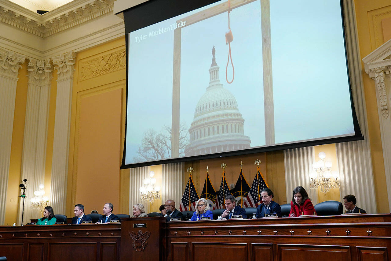 An image of a mock gallows on the grounds of the U.S. Capitol on Jan. 6, 2021, is shown as committee members from left to right, Rep. Stephanie Murphy, D-Fla., Rep. Pete Aguilar, D-Calif., Rep. Adam Schiff, D-Calif., Rep. Zoe Lofgren, D-Calif., Chairman Bennie Thompson, D-Miss., Vice Chair Liz Cheney, R-Wyo., Rep. Adam Kinzinger, R-Ill., Rep. Jamie Raskin, D-Md., and Rep. Elaine Luria, D-Va., look on, as the House select committee investigating the Jan. 6 attack on the U.S. Capitol holds its first public hearing to reveal the findings of a year-long investigation, at the Capitol in Washington, D.C., Thursday. (J. Scott Applewhite / Associated Press)