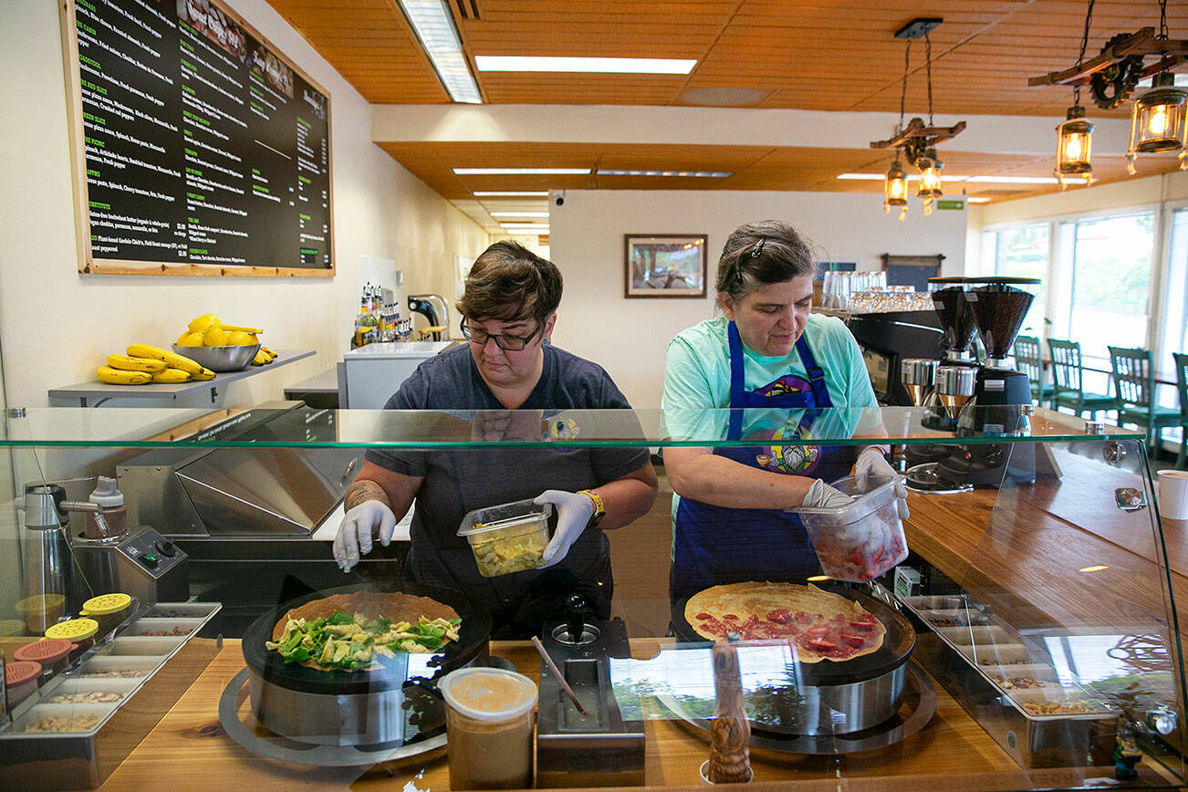 Teresa Godfrey and Sandra Reichstetter work side by side at their new restaurant Thursday, June 9, 2022, at Cup & Crepe on Everett Mall Way in Everett, Washington. The two have been together for over 20 years. (Ryan Berry / The Herald)