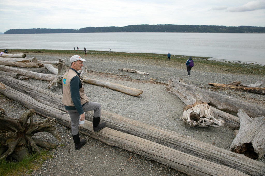 Tim Ellis, a WSU Beach Walker, watches as the water continues to go out during the lowest tide in over a decade Wednesday at Lighthouse Park in Mukilteo. (Ryan Berry / The Herald)
