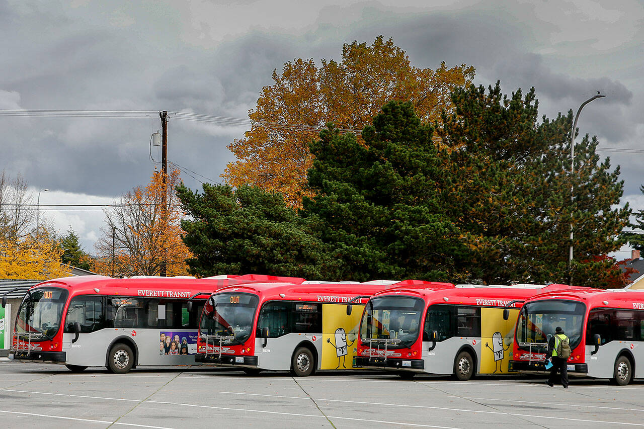 Buses charge October 22, 2021 at the Everett Transit base in Everett. The city plans to continue replacing its diesel and diesel hybrid buses with battery electric buses in its six-year transportation improvement program. (Kevin Clark / Herald file)