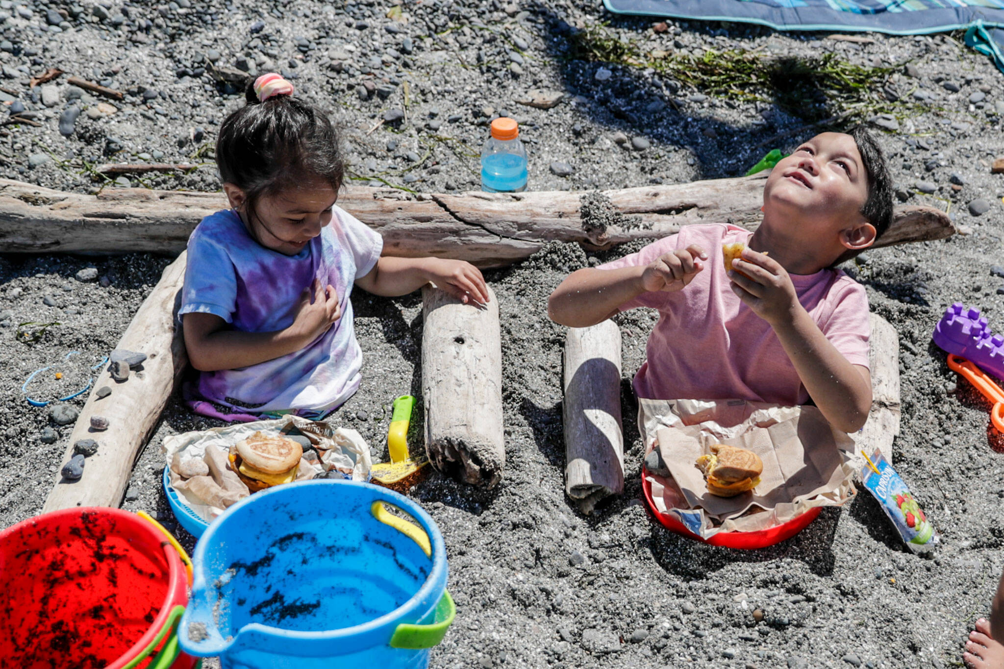 “Nature loungers” Leia Fania, 5, and Luke Fania, 7, enjoy the weather, have lunch and eye the birds Friday afternoon on the Mukilteo beach. (Kevin Clark / The Herald)