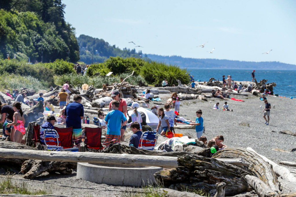 Beach goers enjoy the sun, wind and waves Friday afternoon on the Mukilteo beach. (Kevin Clark / The Herald)
