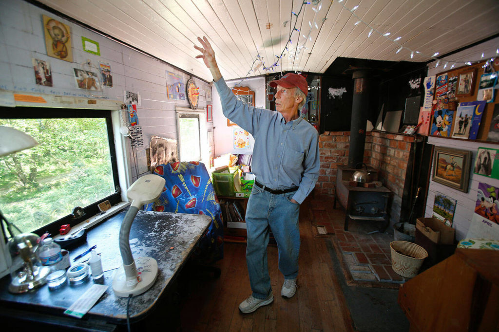 Jim Freeman stands inside the 1928 Milwaukee Road railroad car caboose he called home in 2016 in Freeland, Whidbey Island. (Andy Bronson / The Herald)
