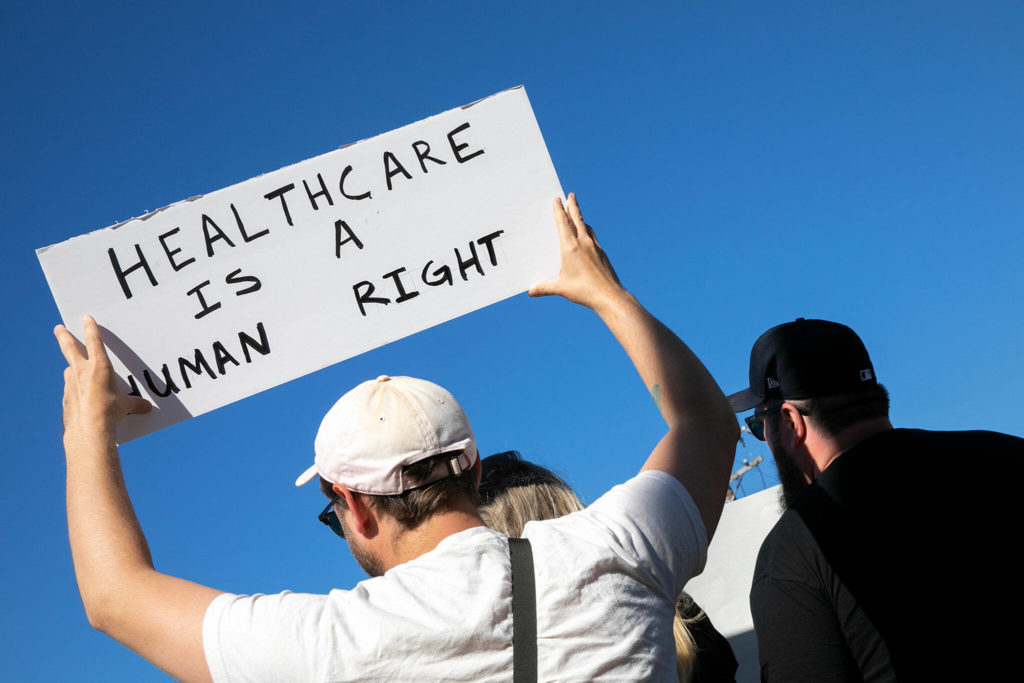 A man holds a sign during a protest against the Supreme Court’s decision to overturn Roe v. Wade on Friday along Broadway in Everett, Washington. (Ryan Berry / The Herald)
