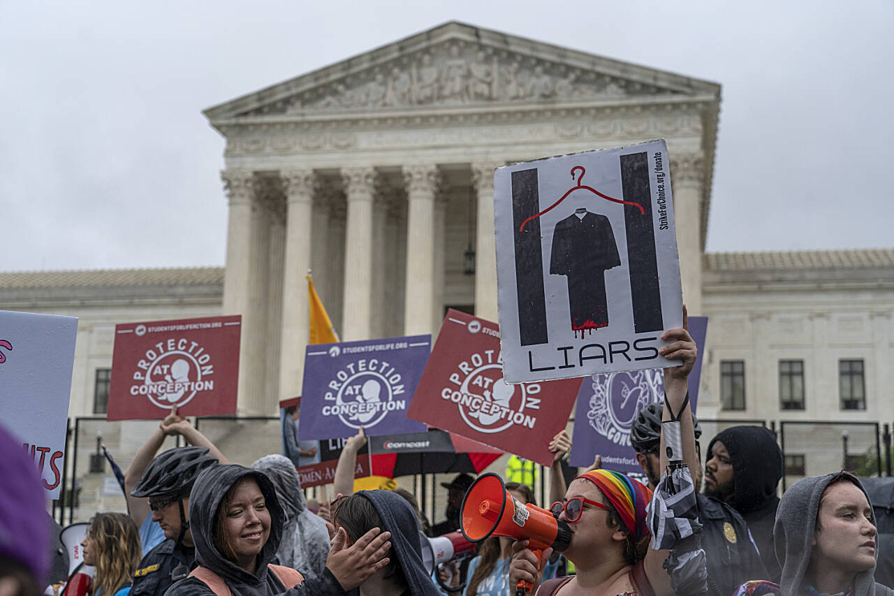 Abortion-rights protesters and anti-abortion protesters, divided by a police line, demonstrate in front of the U.S. Supreme Court in Washington, Thursday. (Gemunu Amarasinghe / Associated Press)