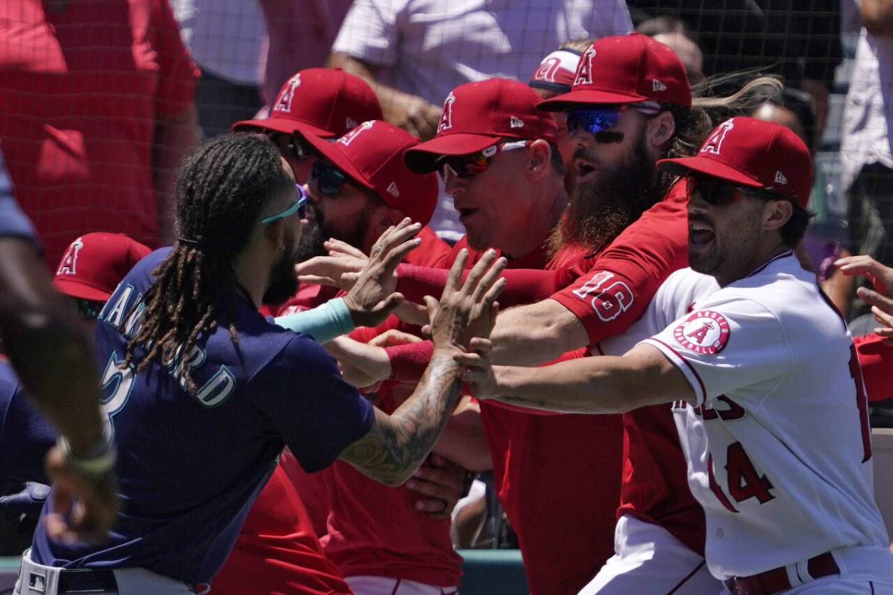 Seattle Mariners’ J.P. Crawford, left, and several members of the Los Angeles Angels scuffle after Mariners’ Jesse Winker was hit by a pitch during the second inning of a game Sunday in Anaheim, Calif. (AP Photo/Mark J. Terrill)