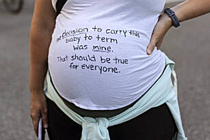 A pregnant protester is pictured with a message on her shirt in support of abortion rights during a march, Friday in Seattle. The U.S. Supreme Court’s decision to end constitutional protections for abortion has cleared the way for states to impose bans and restrictions on abortion; and will set off a series of legal battles. (Stephen Brashear / Associated Press)
