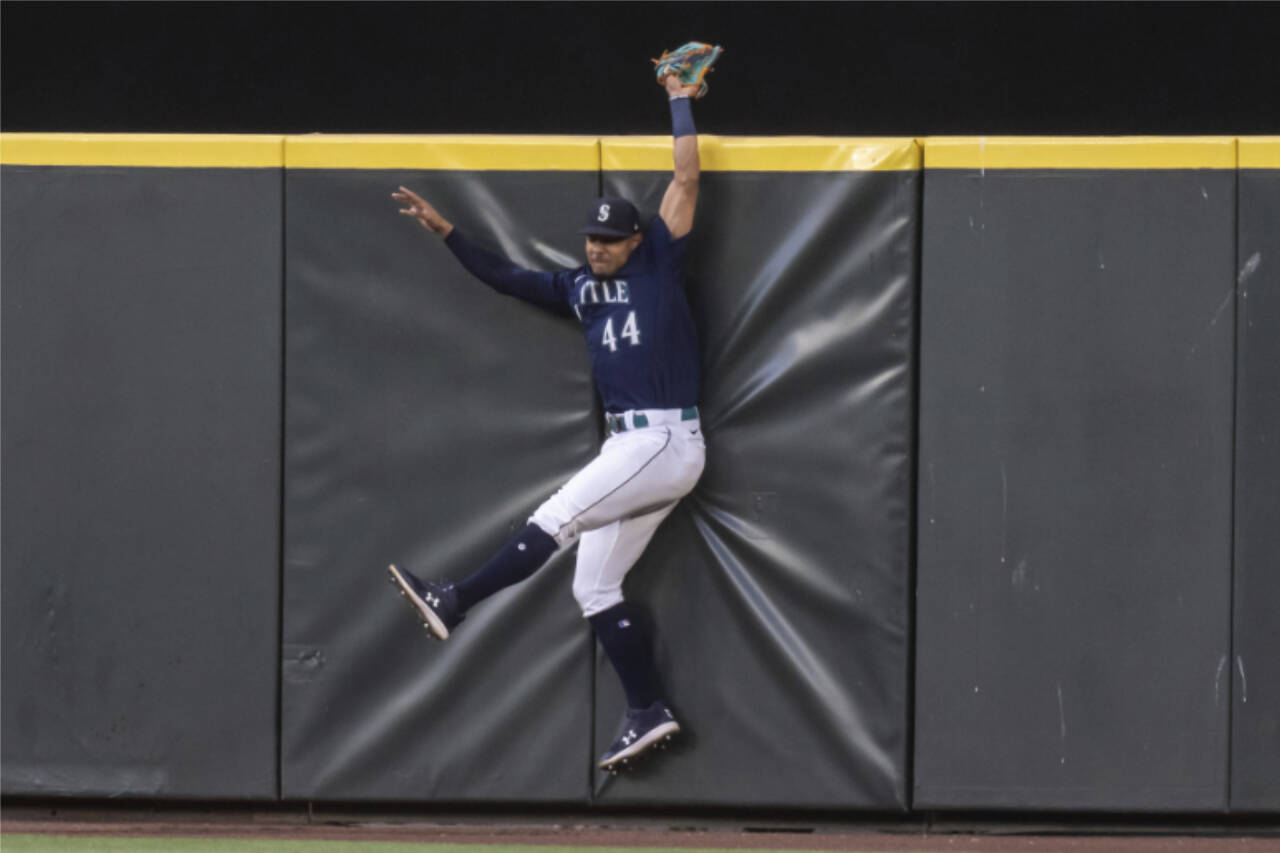 Seattle Mariners centerfielder Julio Rodriguez hits the outfield wall after failing to catch a home run hit by Baltimore Orioles’ Jorge Mateo during the sixth inning of Monday’s game in Seattle. (AP Photo/Stephen Brashear)