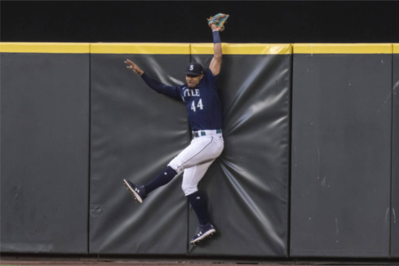 Seattle Mariners centerfielder Julio Rodriguez hits the outfield wall after failing to catch a home run ball hit by Baltimore Orioles' Jorge Mateo during the sixth inning of a baseball game, Monday, June 27, 2022, in Seattle. (AP Photo/Stephen Brashear)