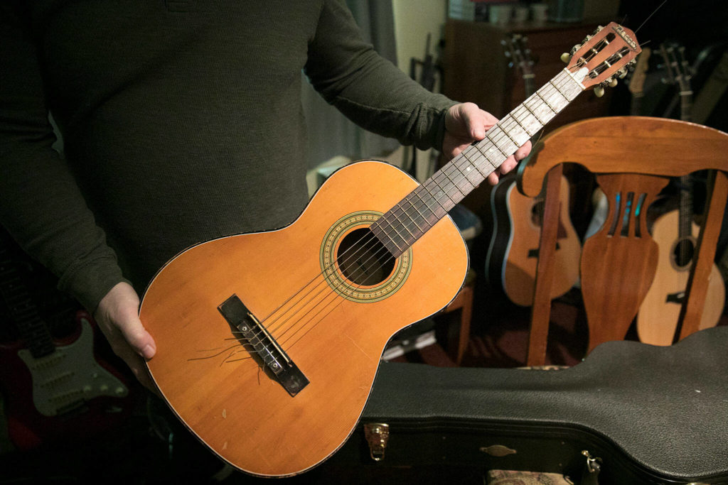 Nik Clovsky still has his first guitar after about 50 years. (Ryan Berry / The Herald)

