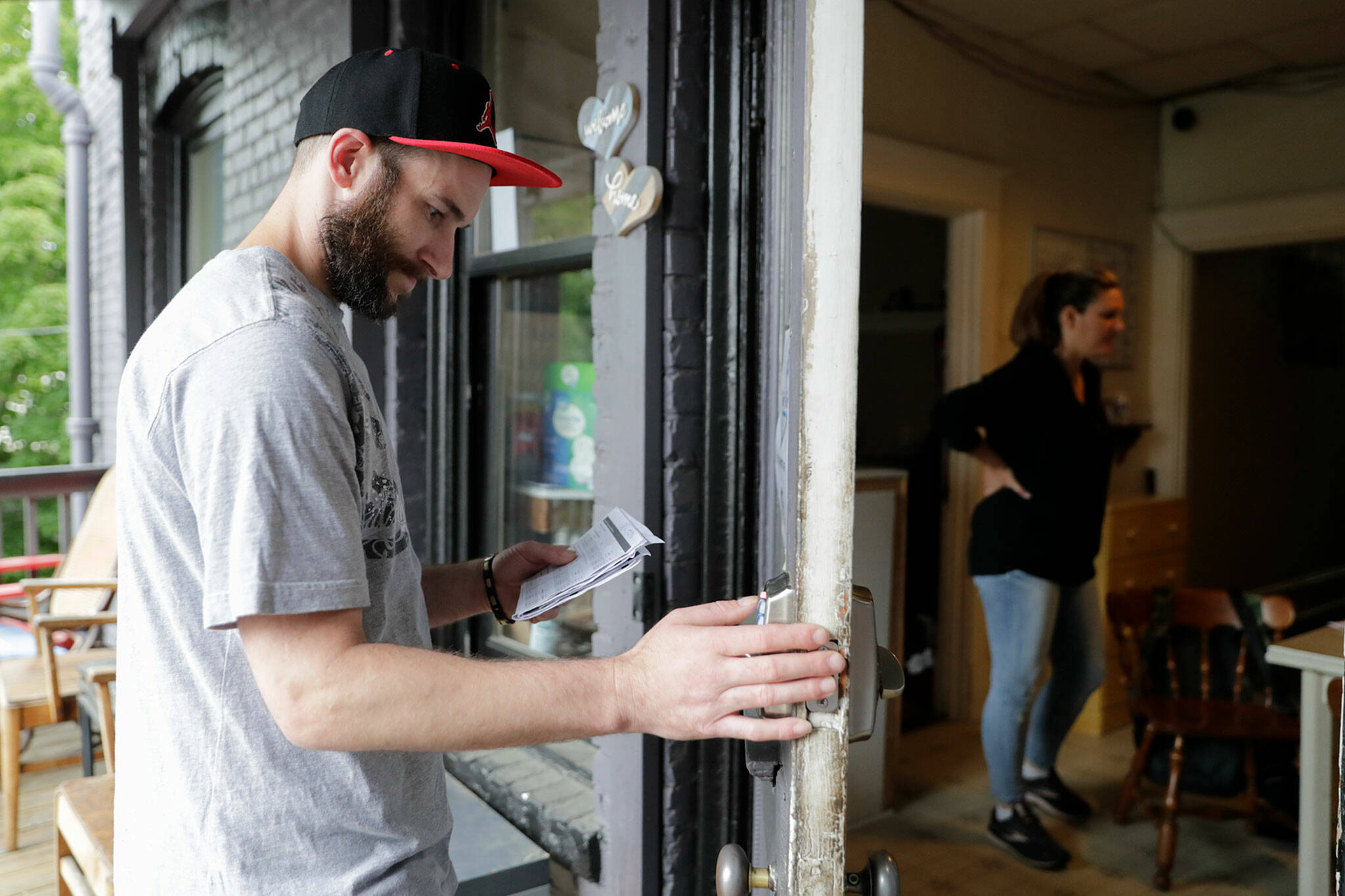 Jimmy Hanson keys in a lock code for a new resident at Nick’s Place in Everett in June. (Kevin Clark / The Herald)