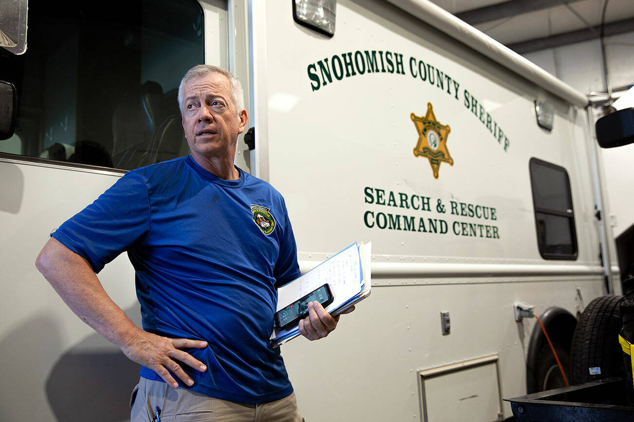 John McKeon stands in front of a mobile headquarters vehicle while discussing the funding needs of Snohomish County Volunteer Search and Rescue on Wednesday, June 22, 2022, at the search and rescue headquarters in Snohomish, Washington. McKeon said a priority for the group is to find money for new covered parking for a number of vehicles that do not have a garage to be parked in. (Ryan Berry / The Herald)