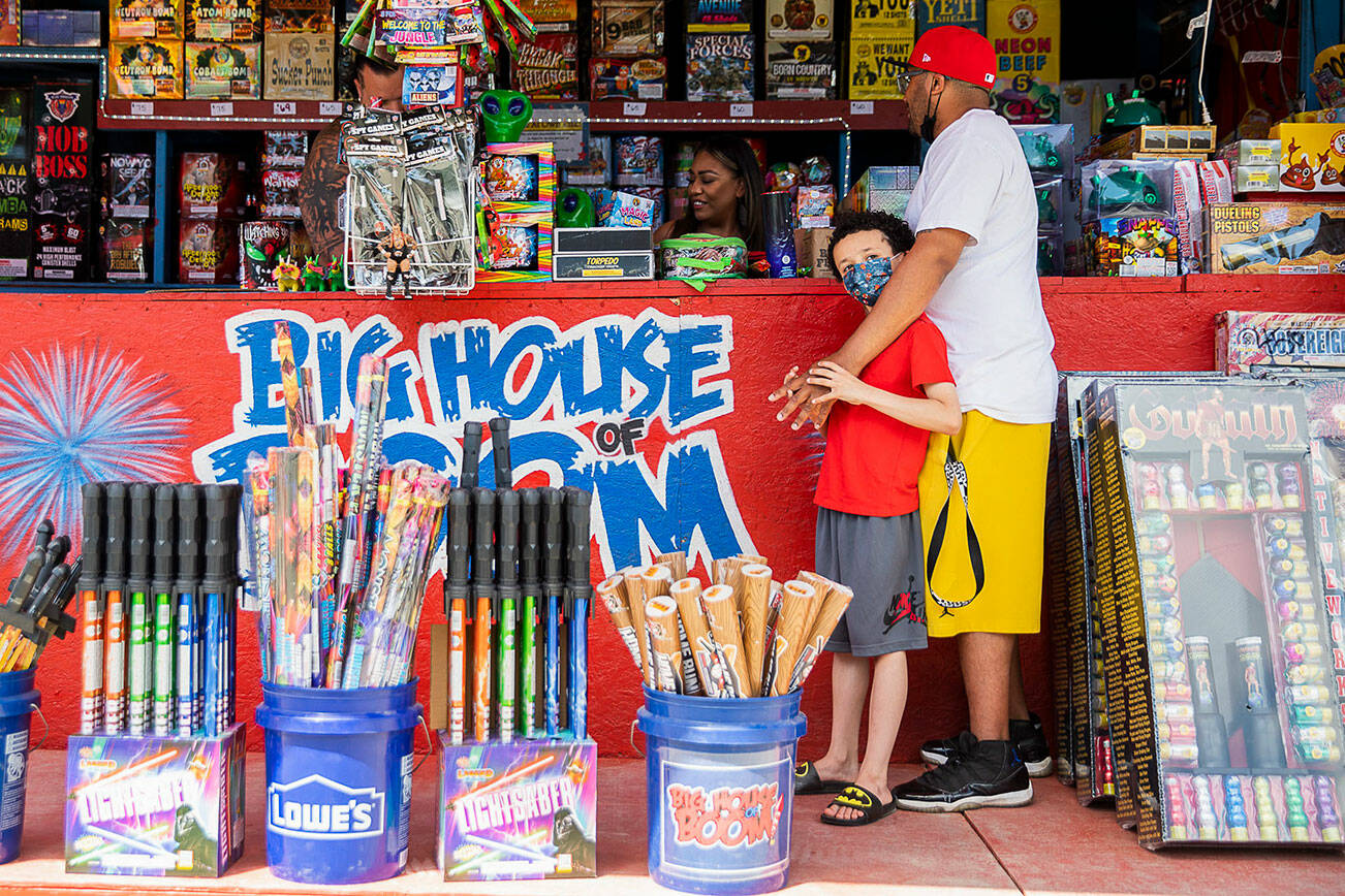 Chris Rutland and son Julian buy fireworks from the Big House of Boom stall at Boom City on Thursday, June 30, 2022 in Tulalip, Washington. (Olivia Vanni / The Herald)