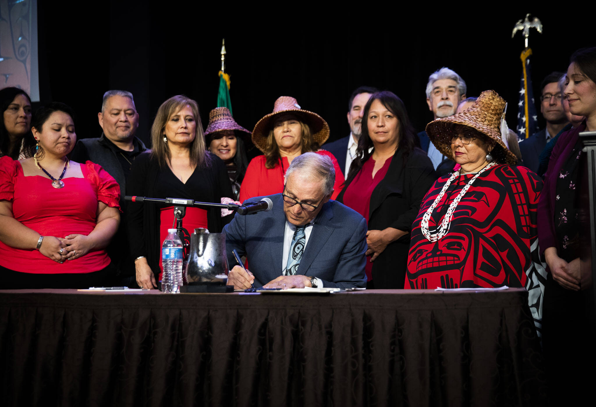 Tulalip council members and tribal members watch as Governor Jay Inslee signs bill HB 1571 into law at the Tulalip Resort on March 31 in Tulalip. (Olivia Vanni / The Herald)