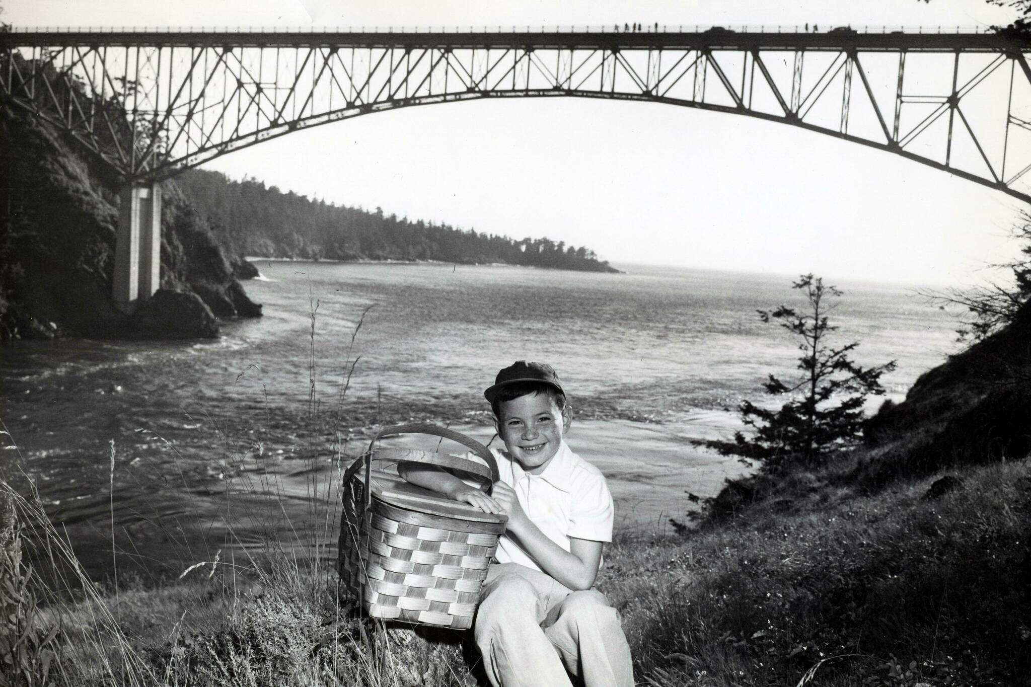 Dept. of Commerce and Economic Development
A boy with a picnic basket is photographed in front of Deception Pass Bridge in 1950.