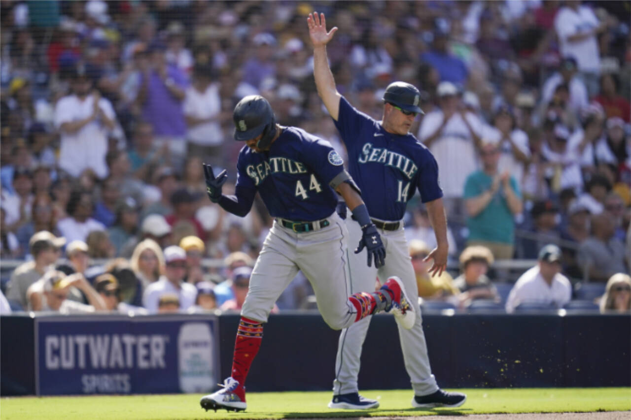 Seattle Mariners’ Julio Rodriguez, left, reacts with third base coach Manny Acta after hitting a two-run home run during the fourth inning of a Monday’s game against the San Diego Padres in San Diego. (AP Photo/Gregory Bull)