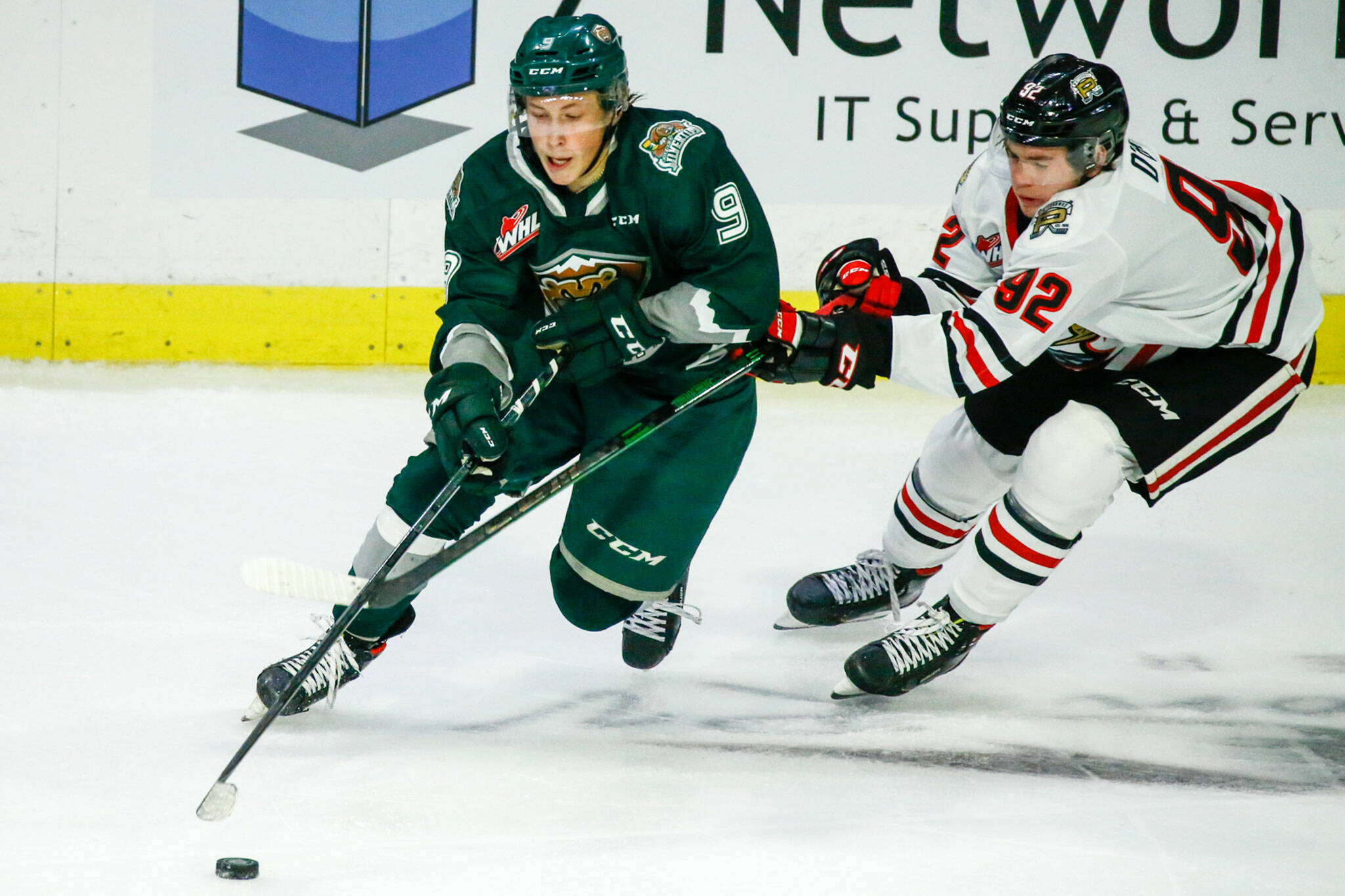 The Silvertips’ Ben Hemmerling controls the puck with Portland’s O’Brien Jack trailing in the second period of a game on Oct. 8, 2021, at Angel of the Winds Arena in Everett. (Kevin Clark / The Herald)