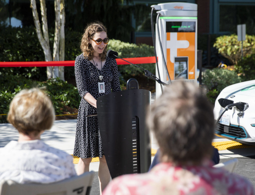 Project manager Suzy Oversvee speaks at the ribbon cutting for two EV charging stations outside of PUD headquarters on Wednesday, in Everett. (Olivia Vanni / The Herald)
