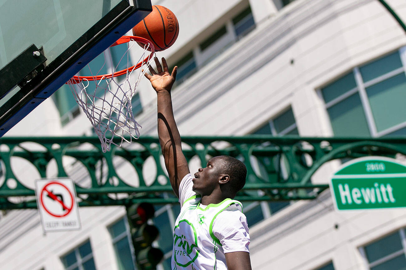 Masamba Njadoe from MUV Elite puts in a layup during the Men’s Elite Championship at Everett 3on3 Sunday, July 10, 2022, in downtown Everett, Washington. (Ryan Berry / The Herald)