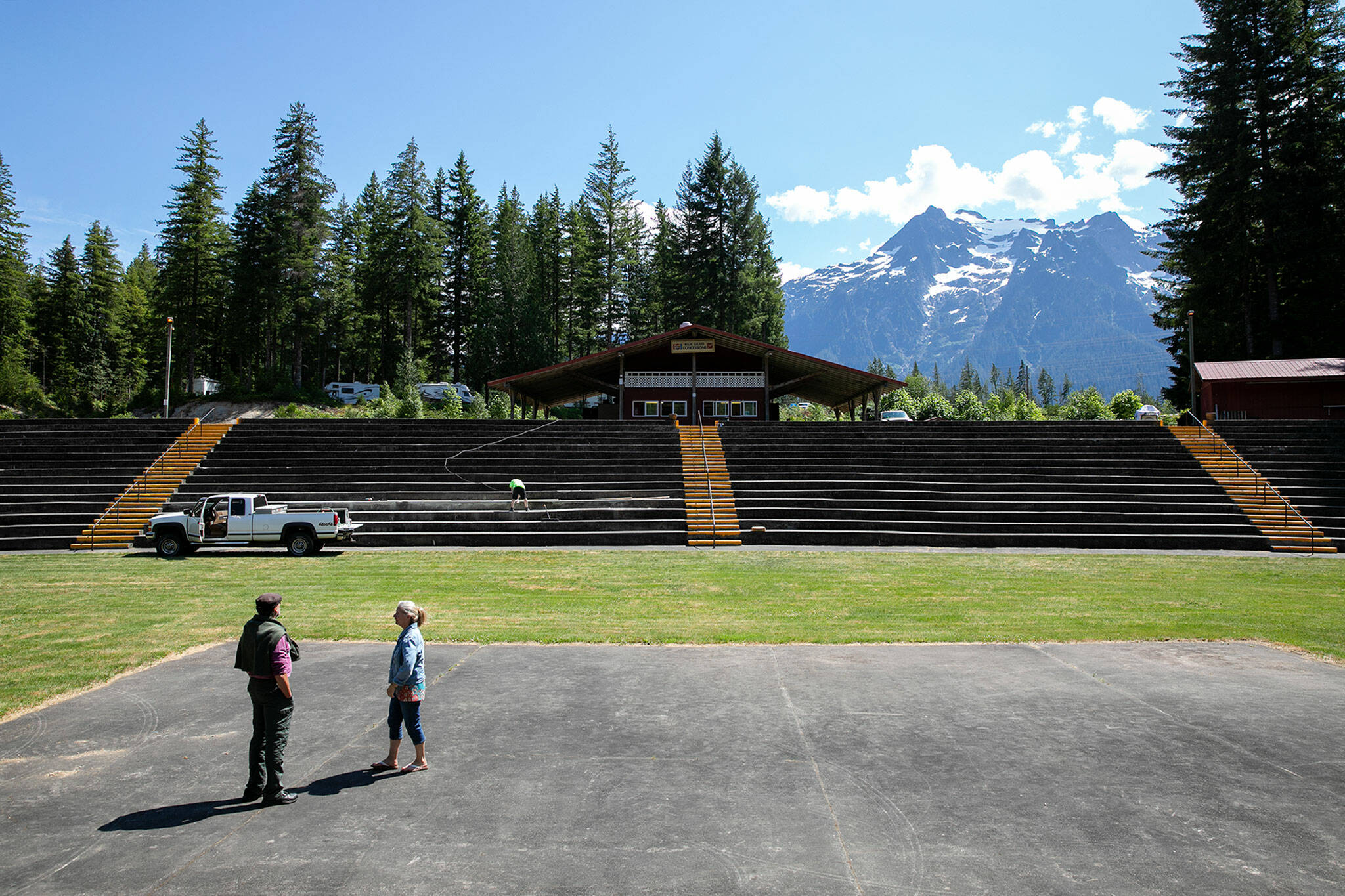 Two early arrivals walk around the amphitheater and take in the view on Wednesday, at Darrington Bluegrass Music Park in Darrington. (Ryan Berry / The Herald)