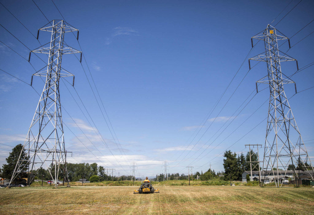 A parks worker mows the large grass field at Frontier Heights Park on Friday in Lake Stevens. (Olivia Vanni / The Herald)
