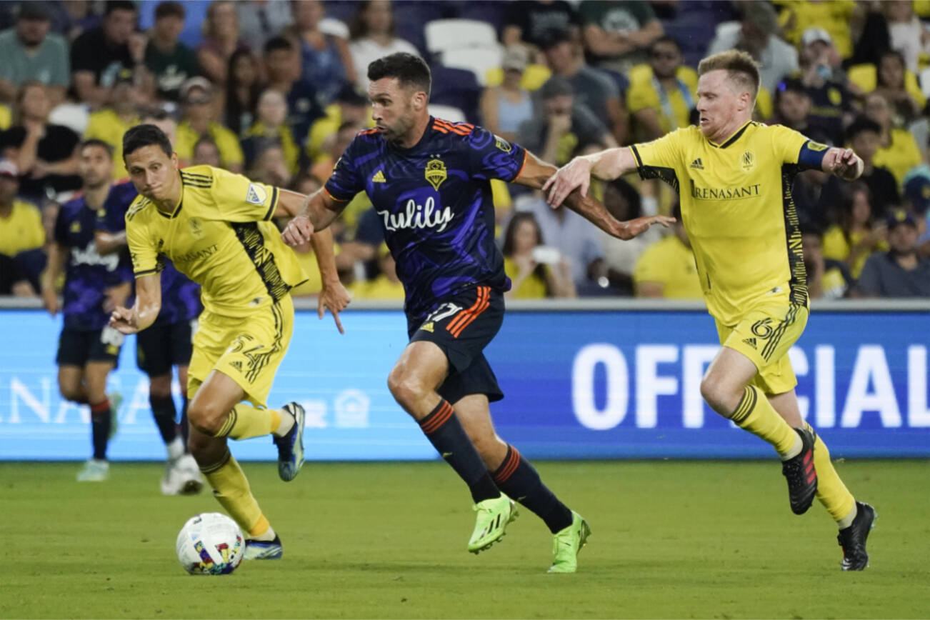 Seattle Sounders' Will Bruin (17) dribbles ahead of Nashville SC's Sean Davis (54) and Dax McCarty (6) during the second half of an MLS soccer match Wednesday, July 13, 2022, in Nashville, Tenn. (AP Photo/Mark Humphrey)