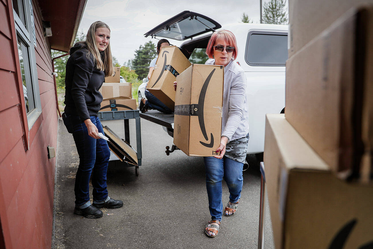 Leslie Wall, left to right. Angela Hill and Cathy Tetzlaff unload donated dog food Monday afternoon at the Everett Animal Shelter in Everett, Washington on July 18, 2022. (Kevin Clark / The Herald)