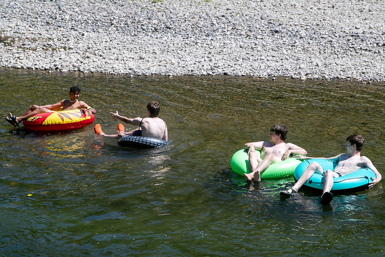 Teenagers tube the waters of the Pilchuck River Wednesday afternoon in Snohomish, Washington on July 20, 2022. (Kevin Clark / The Herald)