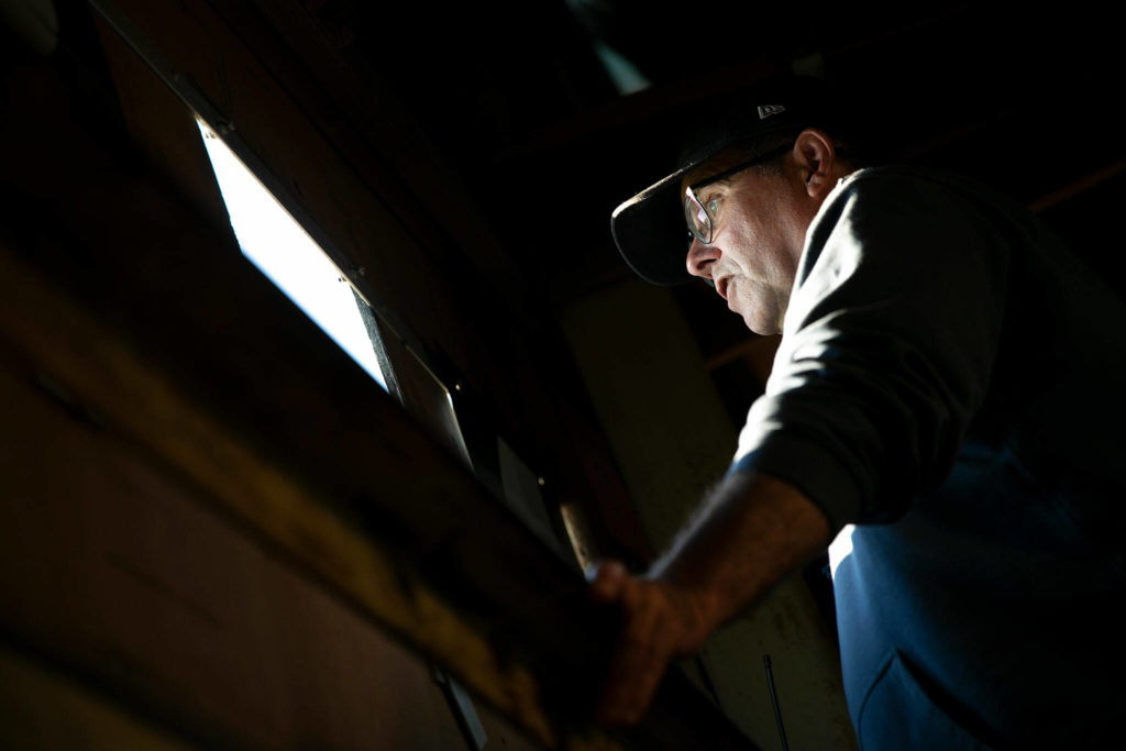 First-year scoreboard operator Craig Hancock takes in the game from his post on Saturday, July 23, 2022, inside the outfield scoreboard at Funko Field in Everett, Washington. (Ryan Berry / The Herald)
